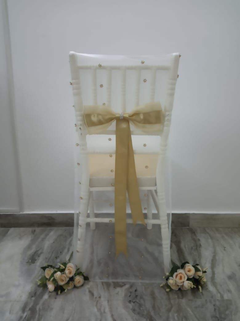 White moti net chair cover with golden tissue and ribbon bow