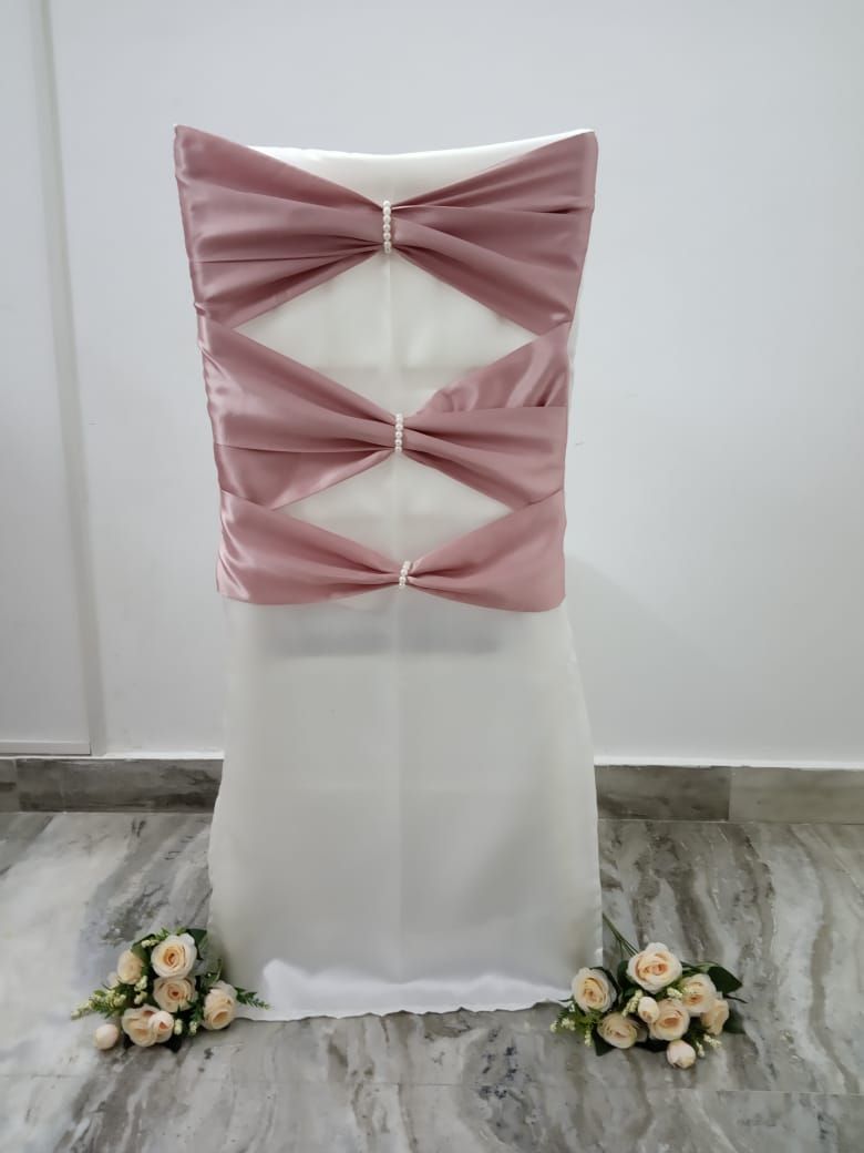 White satin chair cover with rose gold bows